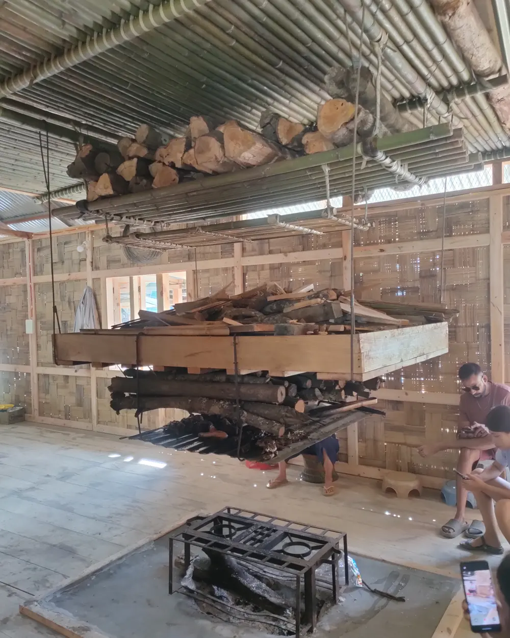 Firewood and smoked meat hanging above the hearth in a traditional Apatani home, Ziro Valley