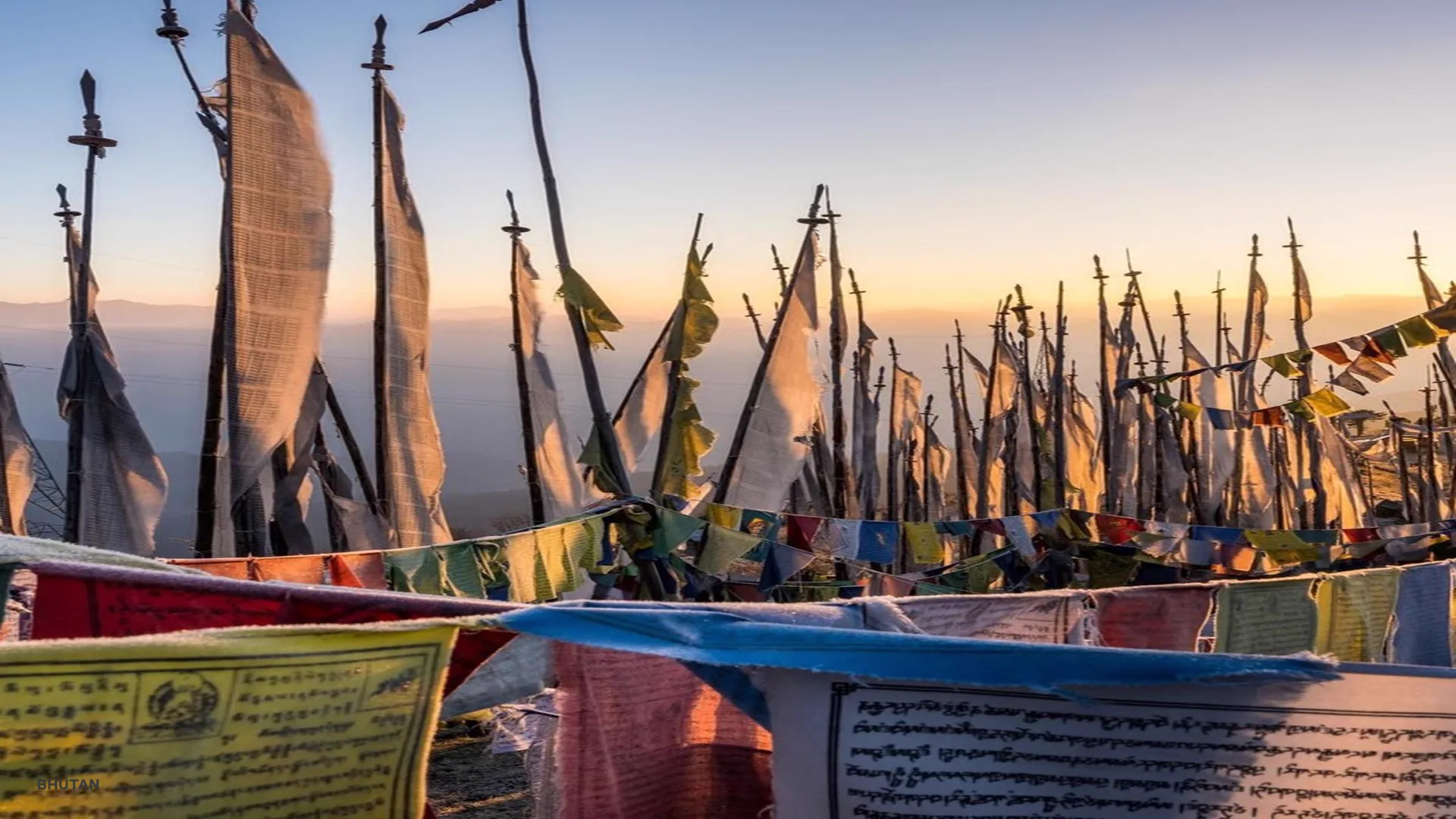 Prayer flags in a mountain valley in Bhutan â€” intimate, small-group travel